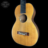Acoustic guitar with a visible brand logo on a black background