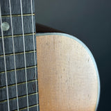 Close-up of a guitar's neck and fretboard on a dark background