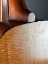 Close-up of a wooden guitar body with a dark brown finish.