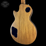 Wooden electric guitar body with 'Tone Shop' logo in the corner.