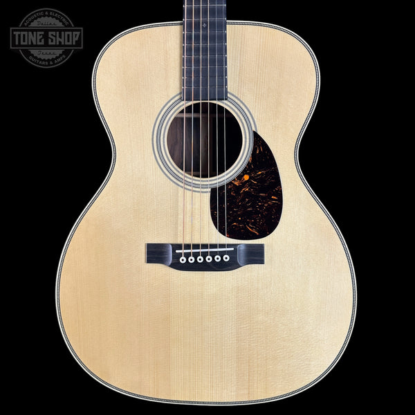 Acoustic guitar with a visible brand logo on a black background