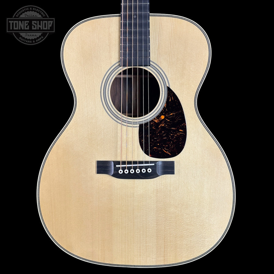 Acoustic guitar with a visible brand logo on a black background