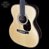 Acoustic guitar with a visible brand logo on a black background