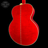 The back of an acoustic guitar with a vibrant red flamed maple top and a gold-toned neck joint, shown against a solid black background with a Tone Shop watermark in the upper left.