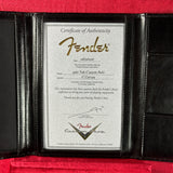 A Fender authenticity certificate insert displayed inside an open black leather folio, set against a red fabric background.