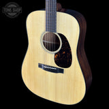 Acoustic guitar with a visible brand logo on a black background