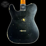 The back of a black Fender Telecaster-style electric guitar body with visible wear, scuffs, and gold-toned hardware, shown against a black background. A Tone Shop watermark is visible in the top-left corner.