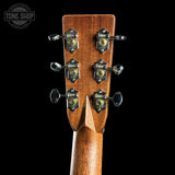 Close-up of a guitar headstock with tuning pegs on a black background, featuring the Tone Shop logo.