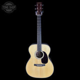 Acoustic guitar with a visible brand logo on a black background
