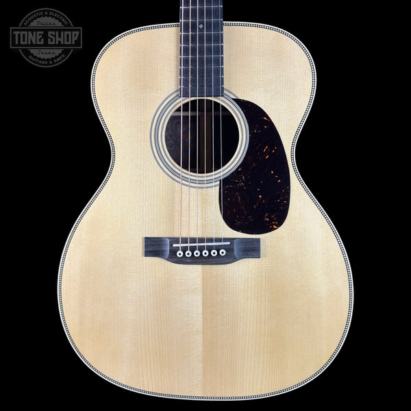 Acoustic guitar with a visible brand logo on a black background