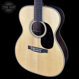 Acoustic guitar with a visible brand logo on a black background