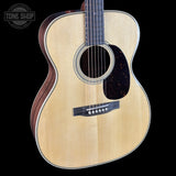 Acoustic guitar with a visible brand logo on a black background