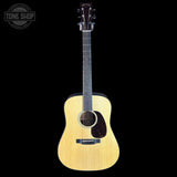 Acoustic guitar with a visible brand logo on a black background