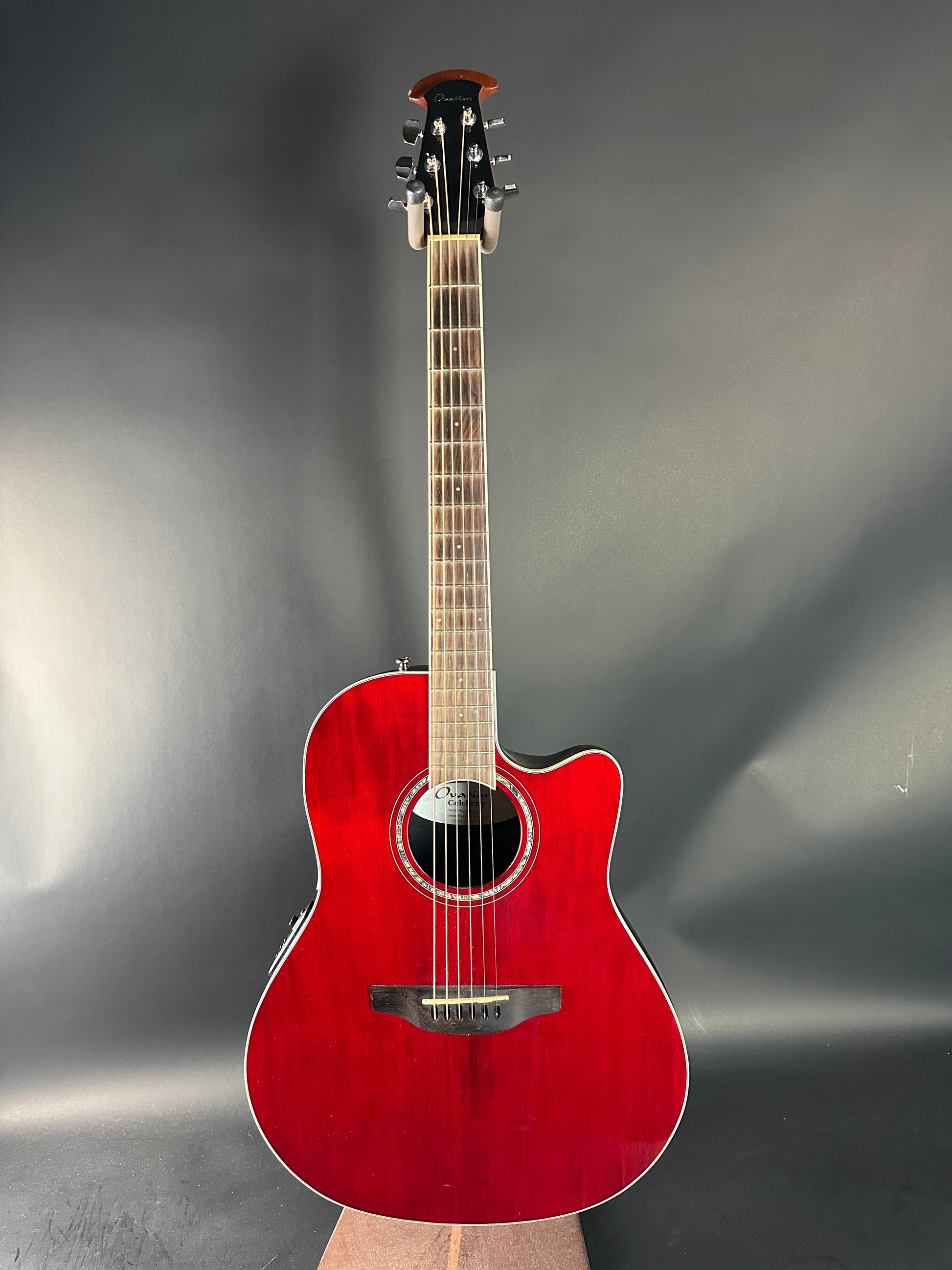 Red acoustic guitar on a reflective gray surface