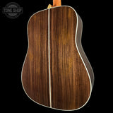 Back view of a wooden acoustic guitar with 'Tone Shop' logo.