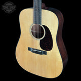 Acoustic guitar with a visible brand logo on a black background