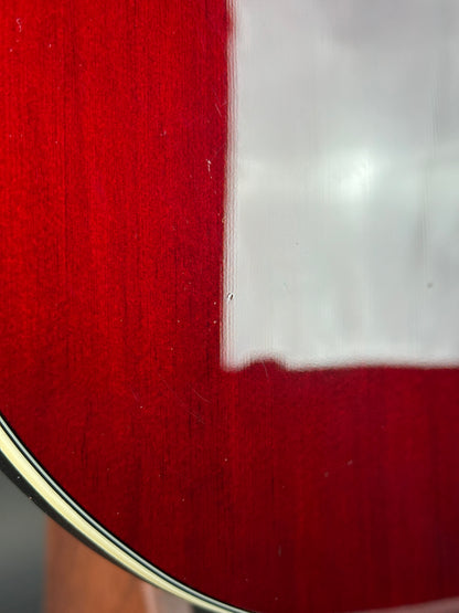 Close-up of a red guitar with a white pickguard