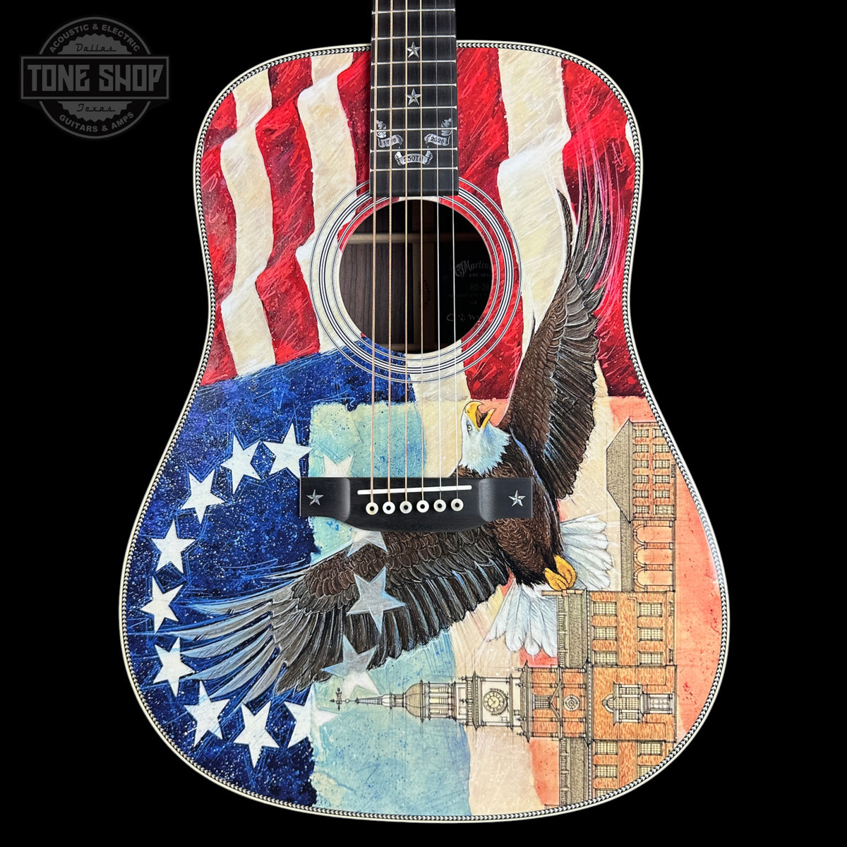 Acoustic guitar with American flag and eagle design on a black background