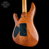 The back of an electric guitar with a glossy warm brown wood finish, black pickguard, and control knobs, shown against a solid black background with a Tone Shop watermark in the top left.