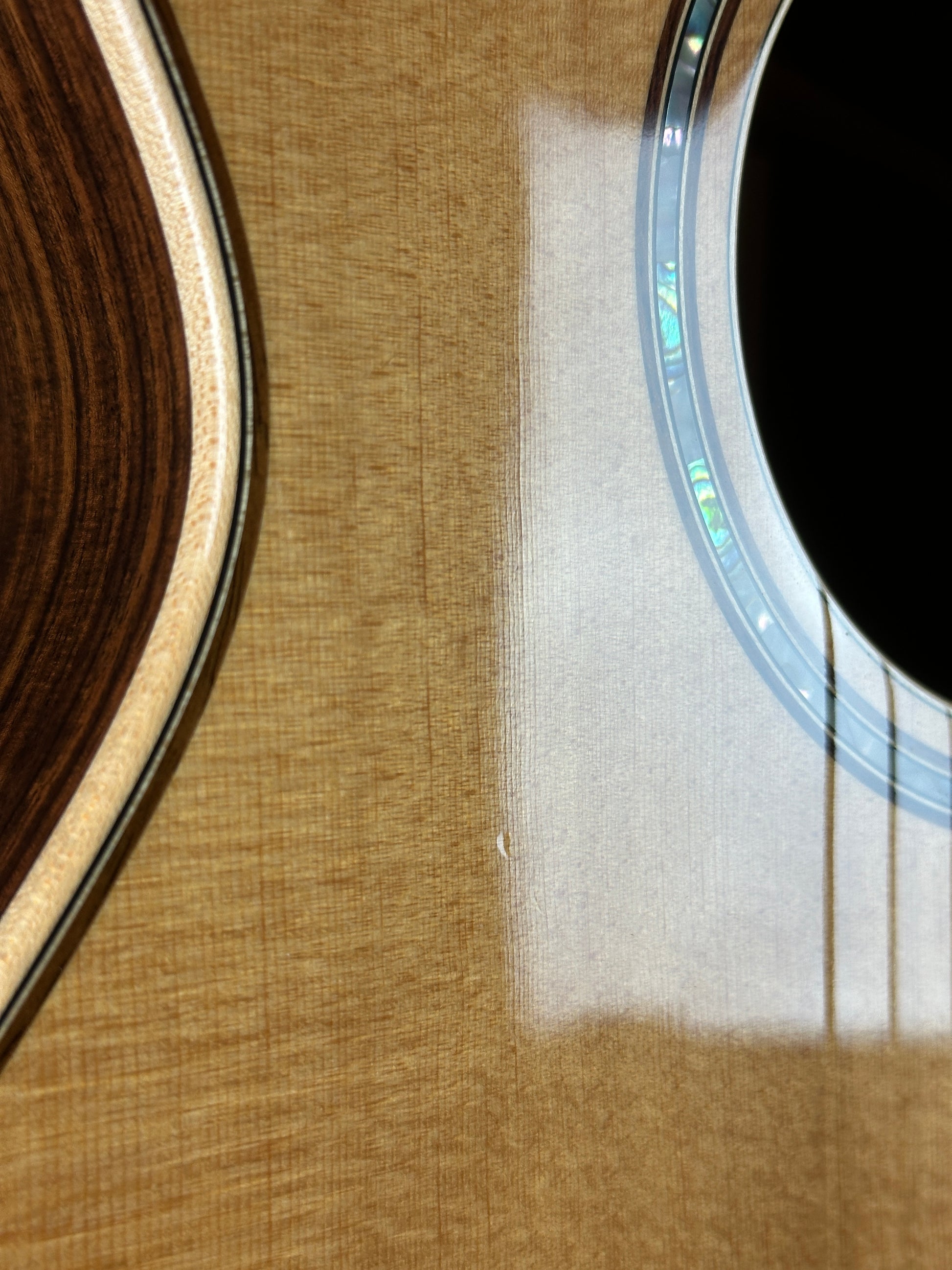 Wear near soundhole of Used Taylor 812ce Natural.