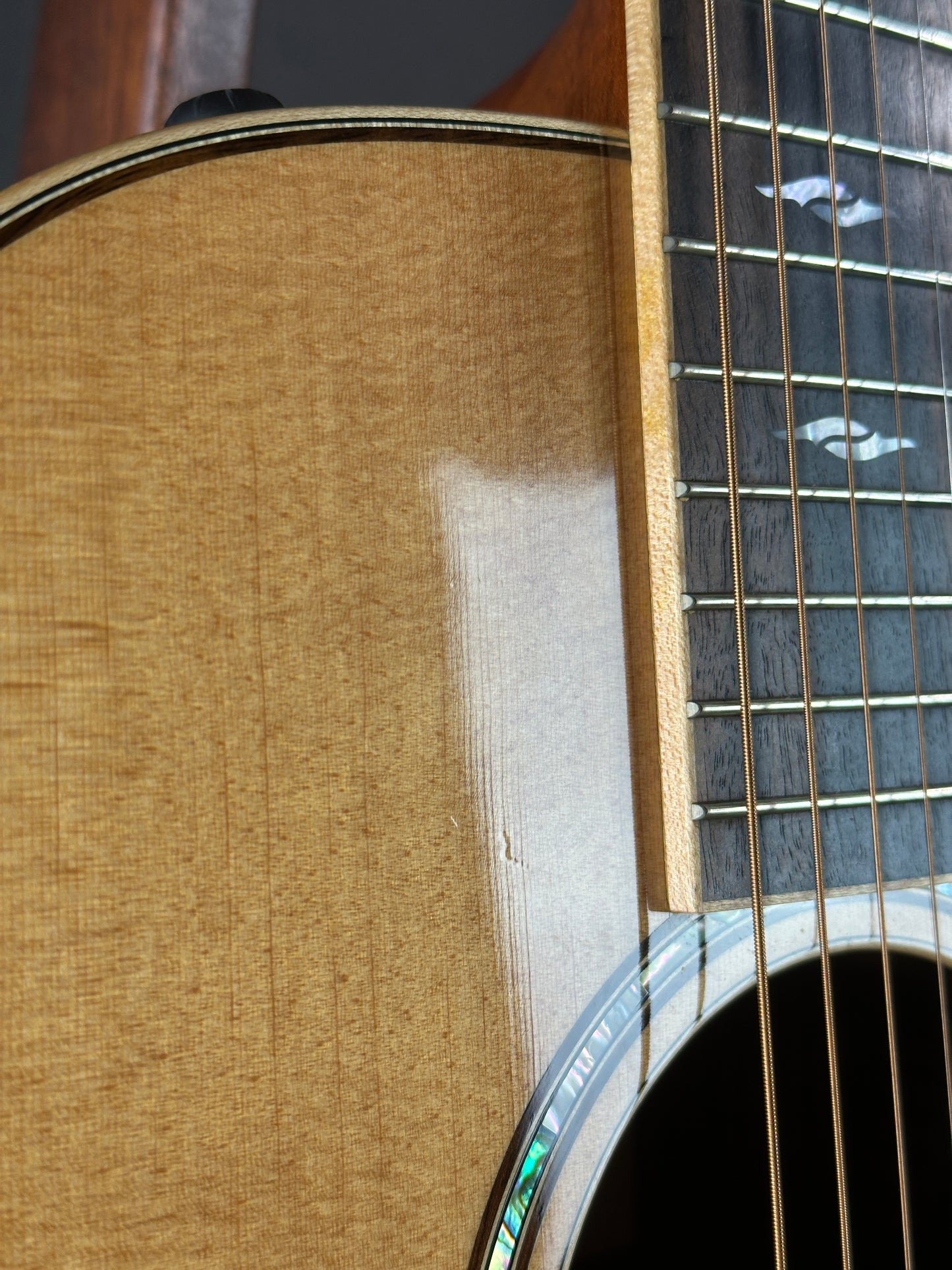Wear near soundhole of Used Taylor 812ce Natural.