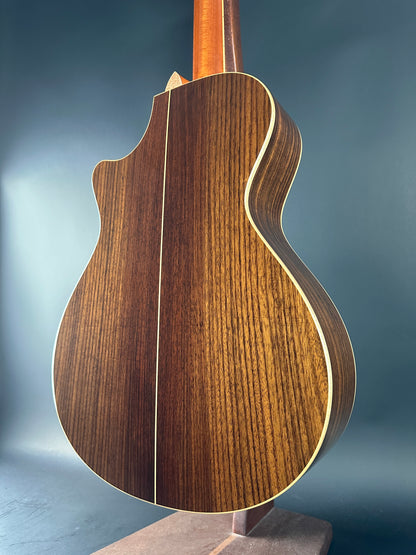 Close-up of a wooden acoustic guitar body on a blue background