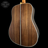 Close-up of a wooden acoustic guitar back with 'Tone Shop' logo.