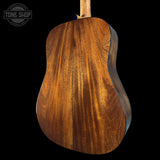 Close-up of a wooden acoustic guitar body with 'Tone Shop' logo.