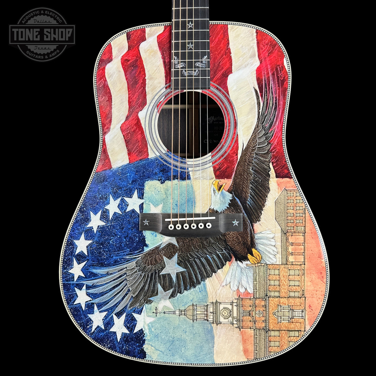 Acoustic guitar with American flag and eagle design on a black background