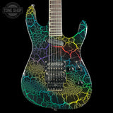 An electric guitar with a black body and vibrant multicolor crackle vein pattern in yellow, green, blue, and purple, shown against a solid black background with a Tone Shop watermark in the top left corner.