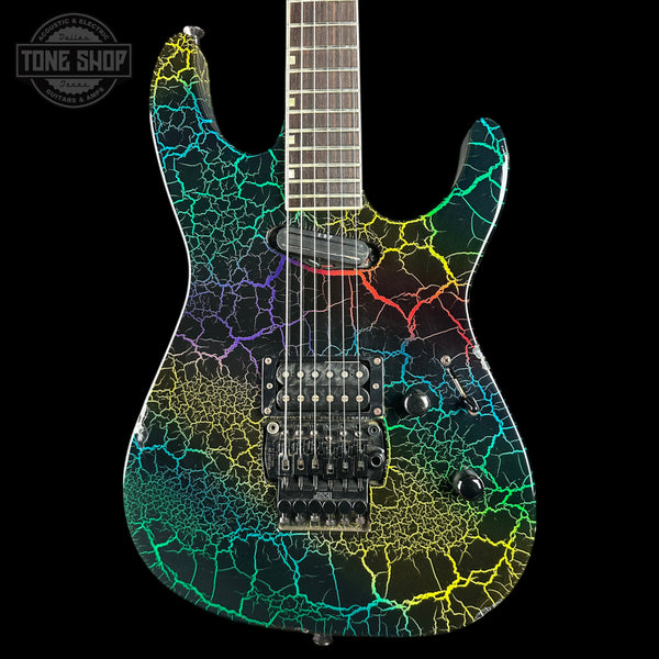 An electric guitar with a black body and vibrant multicolor crackle vein pattern in yellow, green, blue, and purple, shown against a solid black background with a Tone Shop watermark in the top left corner.