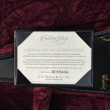 Certificate of authenticity for a Martin Custom Shop guitar on a dark red velvet background