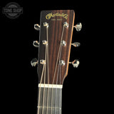 Close-up of a Martin guitar headstock with brand logo on a black background
