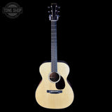 Acoustic guitar with a visible brand logo on a black background