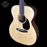 Acoustic guitar with a visible brand logo on a black background