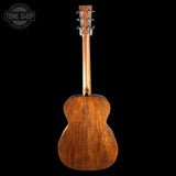 Back view of a wooden acoustic guitar on a black background with 'Tone Shop' logo.