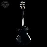 Black electric guitar on a black background with 'Tone Shop' logo.