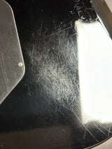 Close-up of a small object on a scratched surface with a light source above.