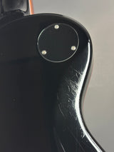 Close-up of a black guitar neck with a shiny finish
