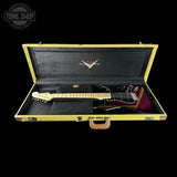 Electric guitar in a black case with a visible brand logo on a black background