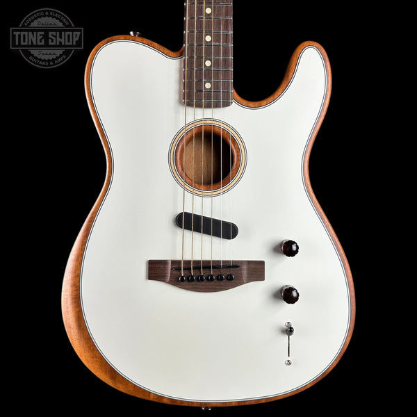 A white electric-acoustic guitar with a natural wood body and dark brown neck, shown against a solid black background. A Tone Shop watermark is visible in the top-left corner.