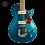 A teal blue electric guitar with a glossy finish, featuring cream-colored humbucker pickups, a brown tortoiseshell pickguard, and chrome hardware, shown against a solid black background.
