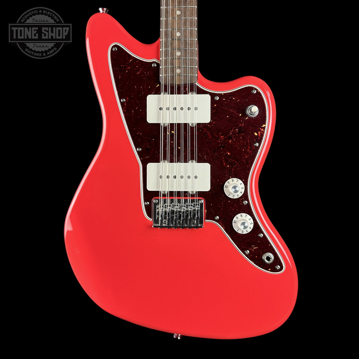 A red electric guitar with a double-cutaway body, white humbucker pickups, and a dark red glittery pickguard, shown against a solid black background. A Tone Shop watermark is visible in the top-left corner.