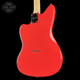 The rear view of a bright red electric guitar body with a maple neck, black pickguard, and chrome hardware, shown against a solid black background.