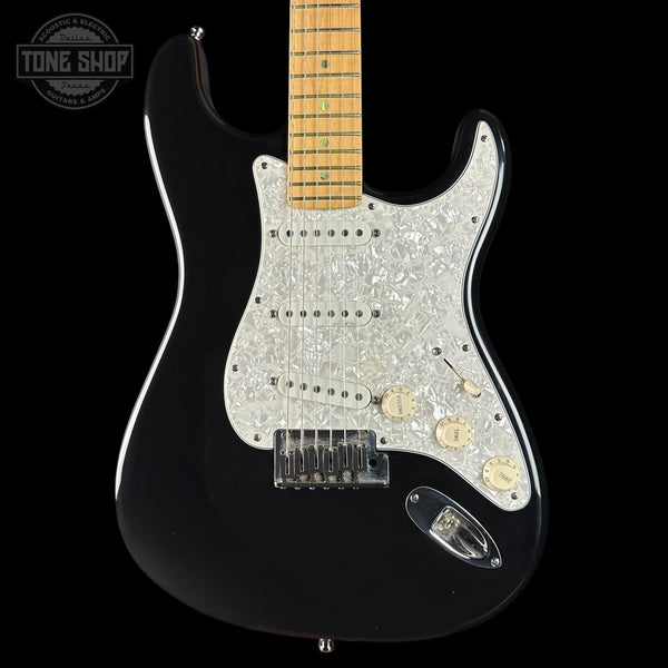 Black electric guitar with a pearlized pickguard on a black background, featuring 'Tone Shop' branding.
