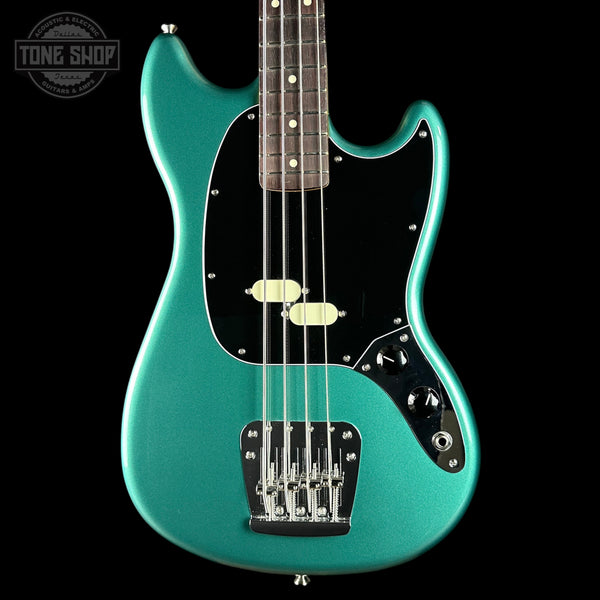Turquoise electric bass guitar on a black background with 'Tone Shop' logo.