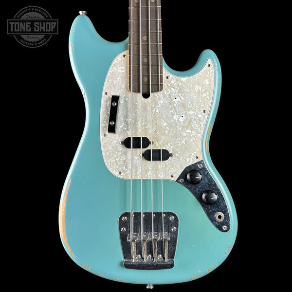 Electric bass guitar with a light blue finish and pearlized pickguard on a black background.