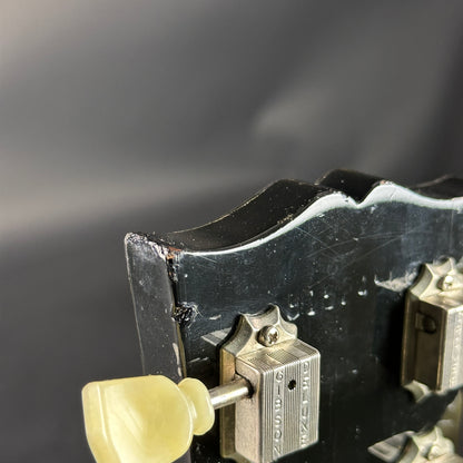 Close-up of a guitar's tuning pegs with a dark background