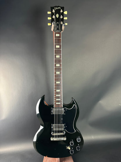 Black electric guitar on a gray background