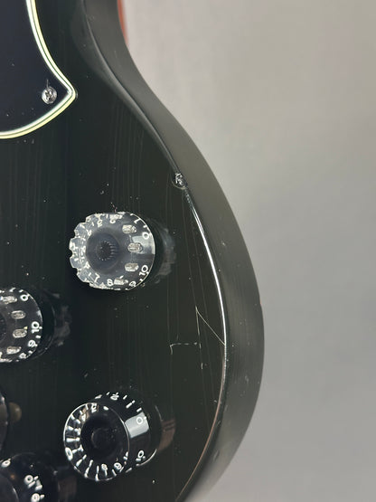 Close-up of a guitar's headstock with tuning pegs on a gray background